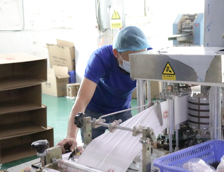 trabalhador de controle de qualidade inspecionando o processo de produção de papel higiênico
